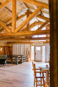 a large room with wooden ceilings and tables and chairs at Anglemont Inn in Anglemont
