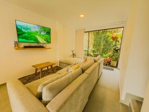 a living room with a couch and a flat screen tv at Casa Turística en el Quindío in La Tebaida