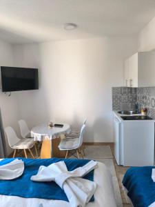 a room with a table and chairs and a kitchen at TOKIs apartmani in Mrkonjić Grad