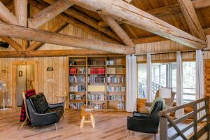 a living room with wooden ceilings and bookshelves at Anglemont Inn in Anglemont