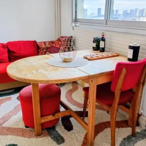 a table with two chairs and a bottle of wine at Appartement Paris vue imprenable in Le Kremlin-Bicêtre