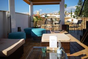 eine Terrasse mit Tisch und Stühlen auf einem Balkon in der Unterkunft Hotel Madinat in Córdoba