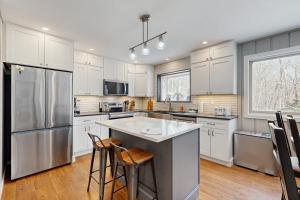 a kitchen with white cabinets and a stainless steel refrigerator at Bear's Crossing Retreat in Dover