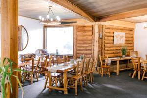a dining room with wooden walls and tables and chairs at Anglemont Inn in Anglemont +28 photos