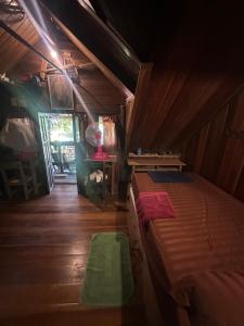 a bedroom with a bed in a room with wooden floors at Tan Homestay in Ko Lanta