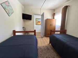 a bedroom with two beds and a television in it at Residencial Mar y Sol in Laraquete +19 photos