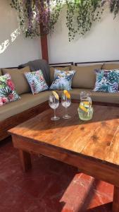 a couch with a wooden table with wine glasses on it at Seasalt & Sand in Mtwapa