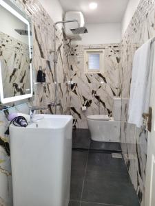 a bathroom with a white sink and a toilet at Astoria Cottage in Nuwara Eliya