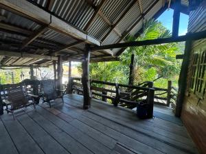 a porch of a house with chairs and a fence at Tan Homestay in Ko Lanta