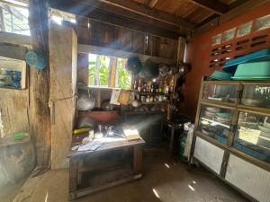 a kitchen with a table in a room with a window at Tan Homestay in Ko Lanta