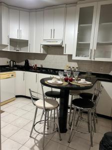 a kitchen with white cabinets and a table and chairs at Equilíbrium Quarto de casal com banheiro compartilhado in Marechal Cândido Rondon