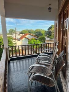 a row of chairs sitting on a balcony at Equilíbrium Quarto de casal com banheiro compartilhado in Marechal Cândido Rondon