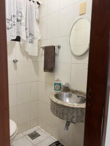a bathroom with a sink and a mirror at Equilíbrium Quarto de casal com banheiro compartilhado in Marechal Cândido Rondon +8 photos