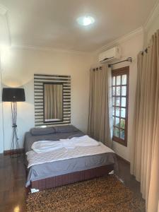 a bed in a room with a window and a bed sidx sidx sidx at Equilíbrium Quarto de casal com banheiro compartilhado in Marechal Cândido Rondon