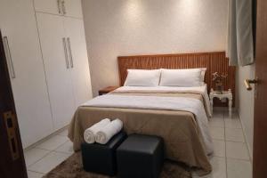 a bedroom with a bed with two towels on it at Costa Family-Casa Costa (downtown Santa Rita) in Santa Rita do Sapucaí