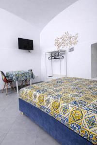 a bedroom with a bed and a table and a chair at Aurora Flavia Suite in Pozzuoli