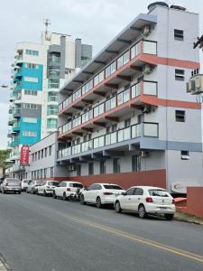 a row of cars parked in front of a building at Hotel Mirante in Barra Velha
