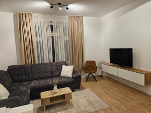 a living room with a couch and a flat screen tv at Sero`s Apartment in Hahnstätten