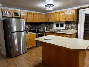 a kitchen with a stainless steel refrigerator and wooden cabinets at The Marmalade Motel in Port Dufferin