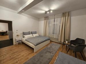 a bedroom with a bed and a chair in it at Sero`s Apartment in Hahnstätten