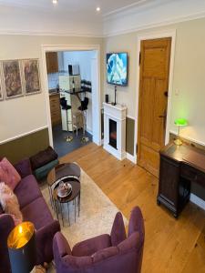 a living room with purple couches and a piano at Whisperwood Apartment in Colnrade
