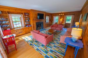 a living room with red chairs and a fireplace at The Colony Hotel Kennebunkport in Kennebunkport