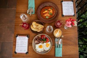 a wooden table topped with plates of breakfast food at The Nest - Complimentary Massage Included in Kigali +49 photos