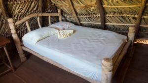 a small bed in a thatch hut at Finca La Magia in Ometepe +85 photos