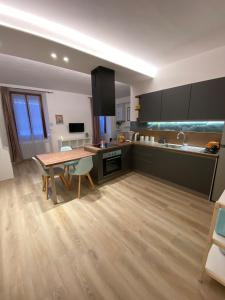 a kitchen with a wooden table and a wooden floor at Casa FATA MELANIA-free parking-self check in in Tavernerio