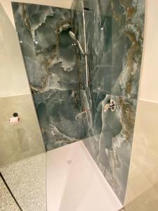 a shower in a bathroom with a stone wall at Casa FATA MELANIA-free parking-self check in in Tavernerio +14 photos