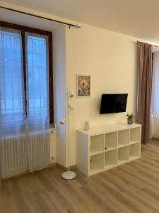a living room with a television and a white entertainment center at Casa FATA MELANIA-free parking-self check in in Tavernerio
