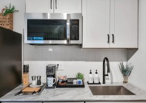 a kitchen counter with a sink and a microwave at Modern Midtown Studio and Private Balcony in Raleigh