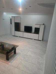 a large room with a tv and a table in it at Ramhouse in Piteşti