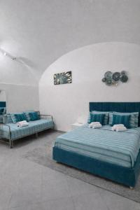 a bedroom with two beds with blue sheets at Diana Flavia Suites in Pozzuoli