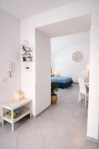 a living room with white walls and a blue bed at Diana Flavia Suites in Pozzuoli
