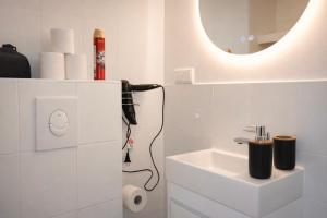 a white bathroom with a sink and a mirror at SOLO by Tendo Stay - Comfort Housing in Falkensee