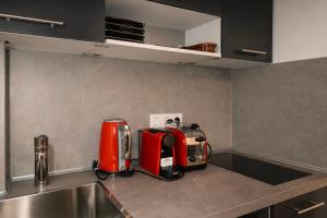 a kitchen with a red appliance sitting on a counter at SOLO by Tendo Stay - Comfort Housing in Falkensee
