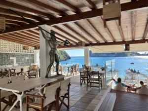 a restaurant with a statue of a man on the wall at Poseidon Beach Bar & Restaurant Apartments in Paleokastritsa