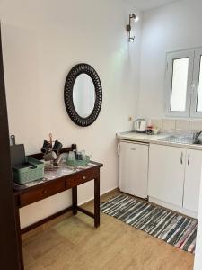 a kitchen with a table and a mirror on the wall at Poseidon Beach Bar & Restaurant Apartments in Paleokastritsa +43 photos