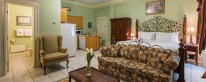 a living room with a bed and a couch and a chair at Chipman Hill Suites -Yeats House in Saint John