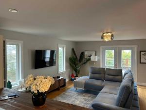 a living room with a couch and a tv at The Marmalade Motel in Port Dufferin