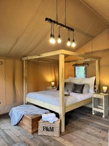 a bedroom with a canopy bed in a tent at Teal Safari Tent in Droitwich