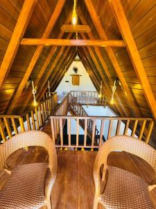a room with two chairs and a wooden ceiling at Sinharaja Brook Cabana in Deniyaya +39 photos