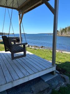 a porch swing with a view of the water at The Marmalade Motel in Port Dufferin