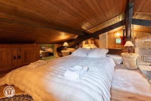 a large white bed in a room with wooden ceilings at Petit chalet l Authentique Annecy in Dingy-Saint-Clair