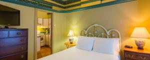 a bedroom with a white bed and a television at Chipman Hill Suites -Yeats House in Saint John