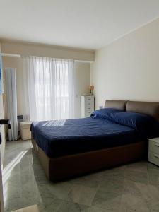 a bedroom with a bed with blue sheets and a window at Victoria Plaza in Menton