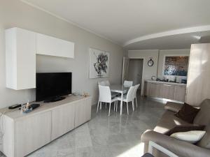 a living room with a television and a table with chairs at Victoria Plaza in Menton