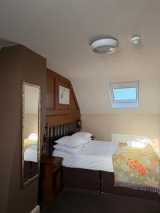 a bedroom with a large bed and a mirror at Crown & Anchor Inn in Brough