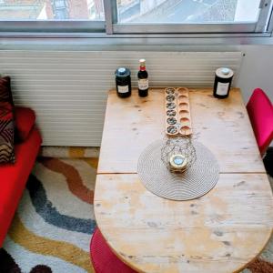 a wooden table with two bottles and a hat on it at Appartement Paris vue imprenable in Le Kremlin-Bicêtre